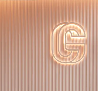The illuminated interlocking G monogram glowing against a fluted blush-pink wall