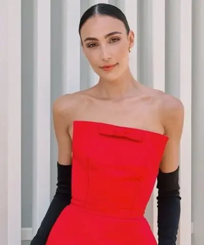Guest in a red strapless bow-front dress with long black opera gloves, hair centre-parted and swept into a low bun